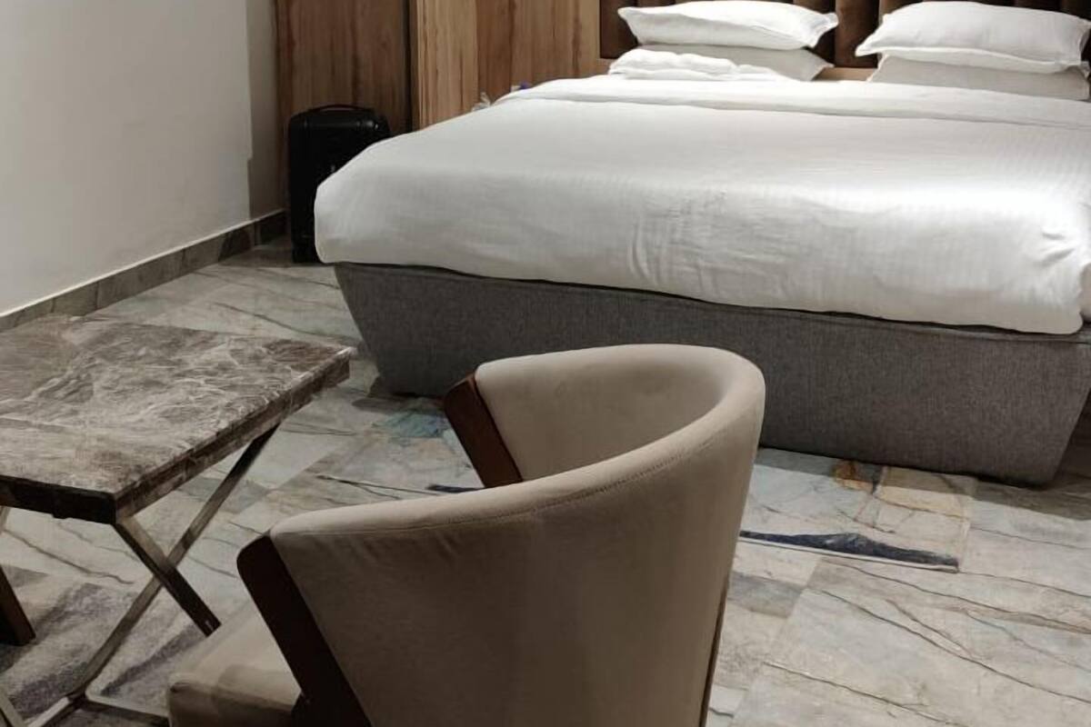 Een moderne slaapkamer met een bed, een stoel, een kledingkast en een airconditioner.