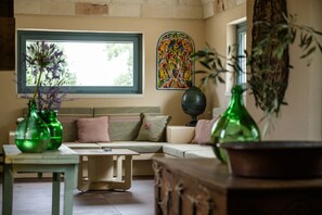 A cozy living room with a sectional sofa, a coffee table, and decorative vases.