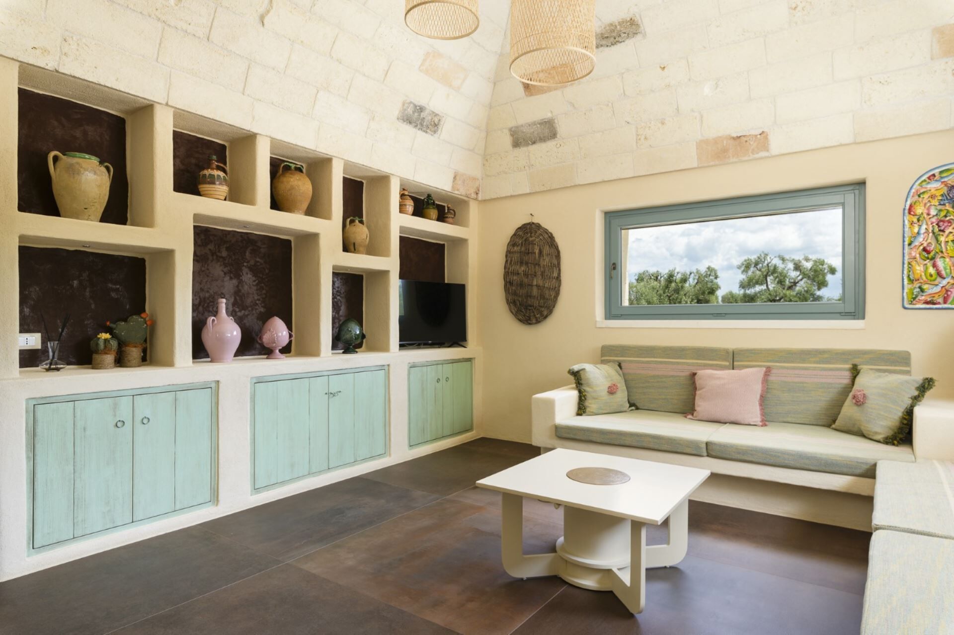 Una habitación con sofá, una mesa y estanterías con diversos objetos.