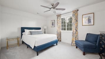 Queen bedroom with a navy accent chair