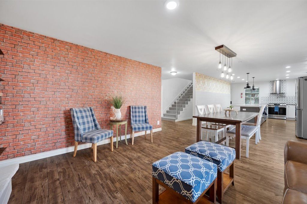 Red brick accent wall with sitting area and the kitchen beyond