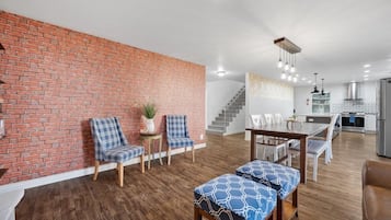 Red brick accent wall with sitting area and the kitchen beyond