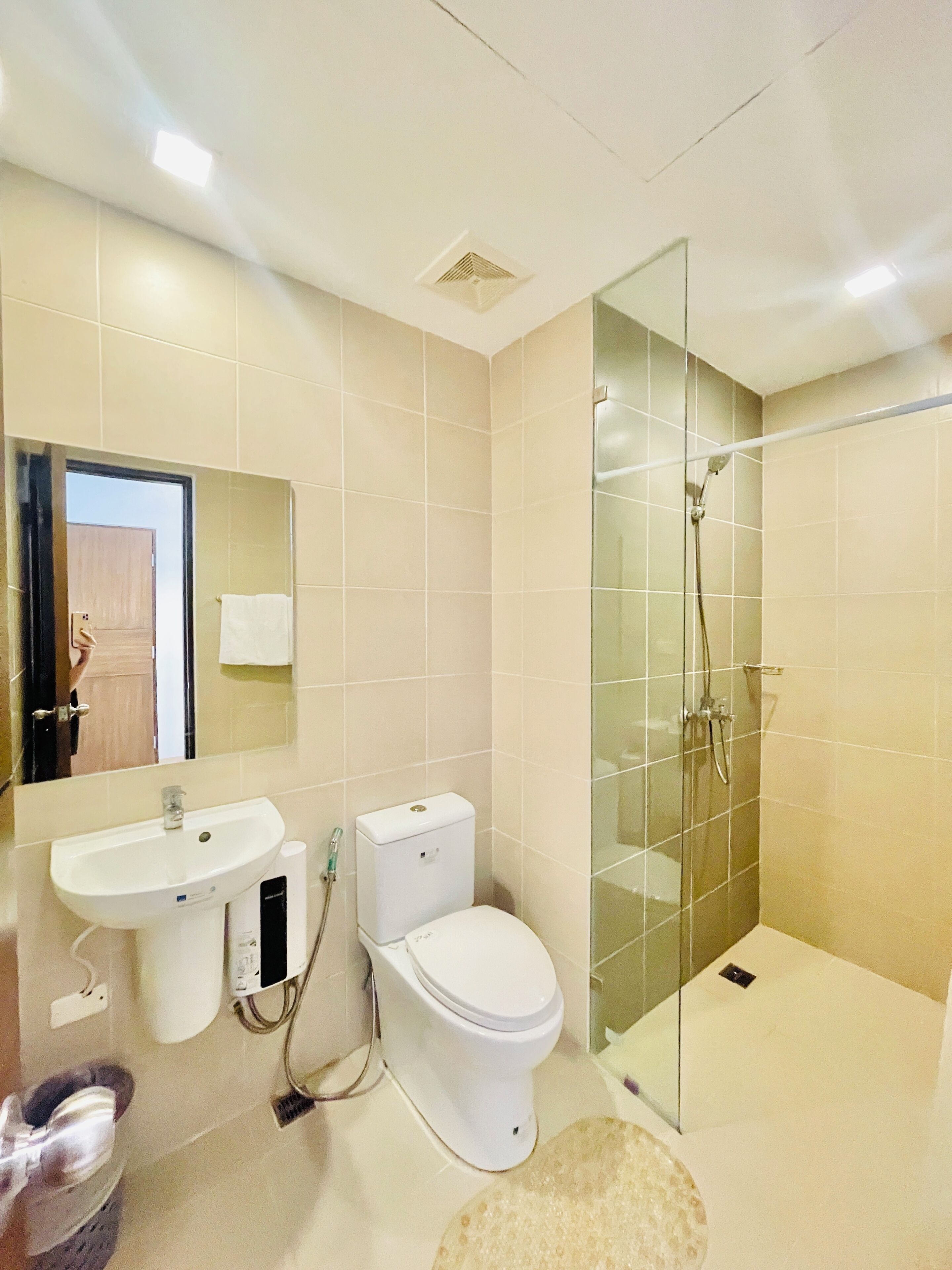 A modern bathroom with a sink, toilet, and glass-enclosed shower.