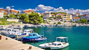 A marina with boats docked, surrounded by residential buildings and greenery. - Spacious 2 Bedroom Apartment With Balcony (Sibenik)