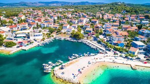 An aerial view of a coastal town with a marina, boats, and a beach. - Spacious 2 Bedroom Apartment With Balcony (Sibenik)