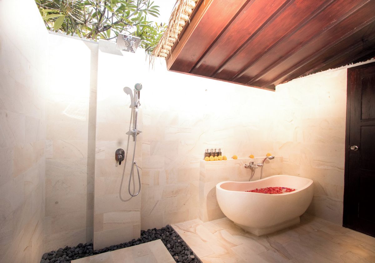 Open-air bathroom with freestanding tub and rain shower