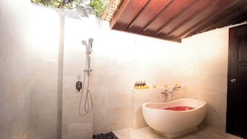 Open-air bathroom with freestanding tub and rain shower