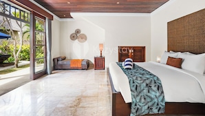 Un dormitorio amplio con una cama grande, techo de madera y vistas al exterior.
