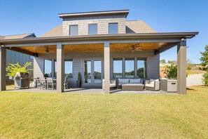 Una casa moderna con un porche cubierto, mobiliario exterior y una zona de barbacoa.
