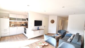 A modern apartment with a kitchen, dining area, and living room. - Vacation apartment Molle (Norden)