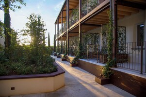 Un immeuble à plusieurs étages doté de balcons, d’espaces de détente en plein air et de verdure.