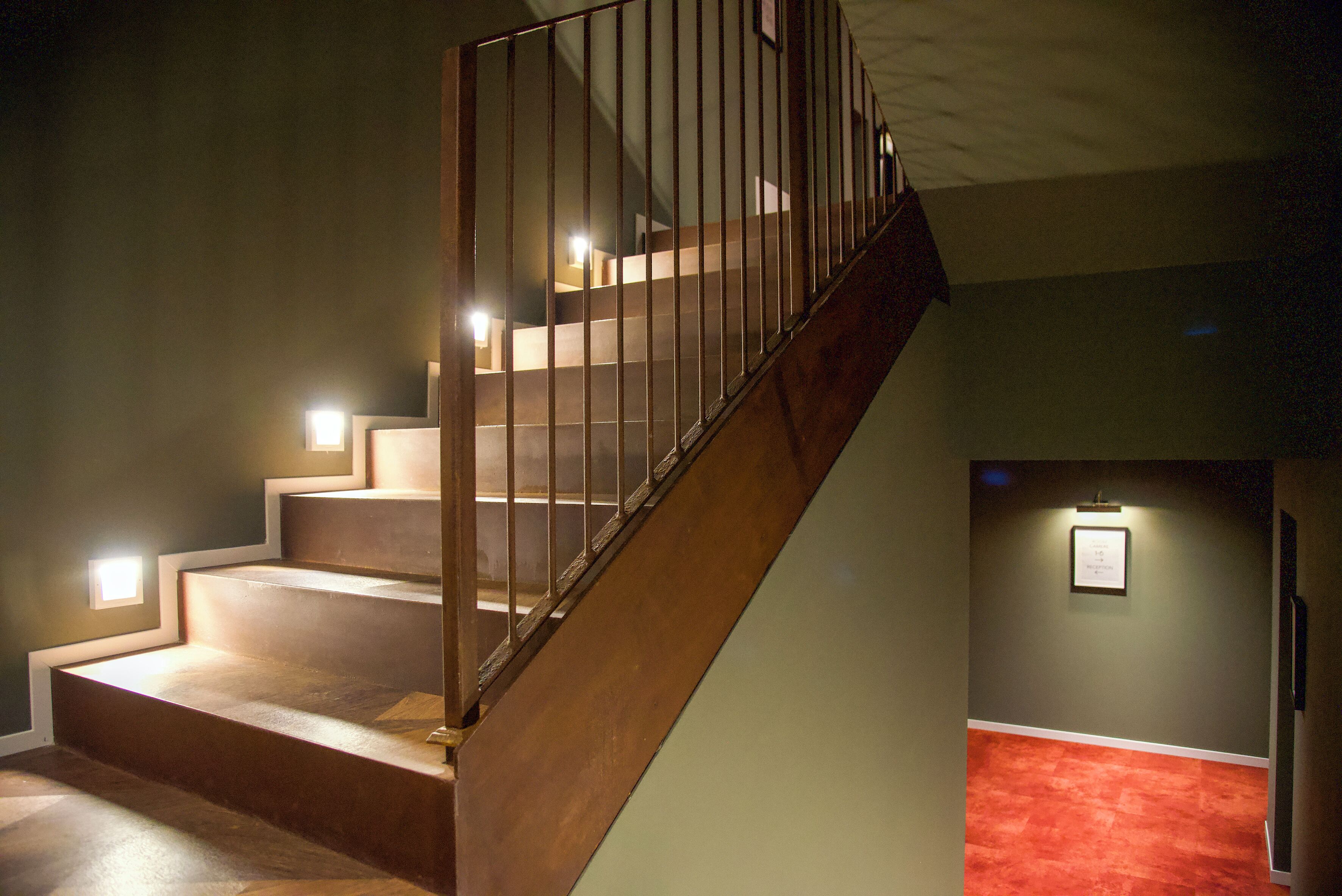 Una escalera de madera con barandillas de metal que conduce a un piso superior.