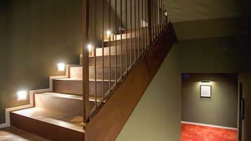 Una escalera de madera con barandillas de metal que conduce a un piso superior.