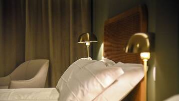 Een hotelkamer met een bed, een lamp, een stoel en een raam met gordijnen.