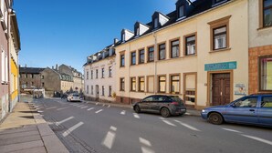 Une rue bordée d’immeubles, dont l’un porte une enseigne indiquant « SANCTUARY », avec une porte et des fenêtres.