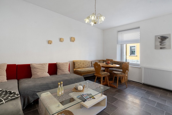 Un salon moderne avec un canapé, une table basse et un coin repas.