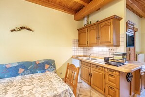 Une cuisine compacte avec des meubles en bois, un four encastré et un petit évier.