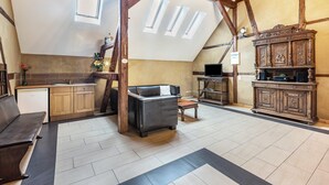 Ein Loft-Zimmer mit Küche, einer Couch, einem Esstisch und einem Holzschrank.