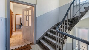 Eine Treppe mit Metallgeländern, eine Tür zu einem Raum und eine Fußmatte auf dem Boden.