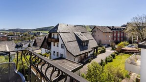 A residential area with houses, a balcony, and a clear sky.