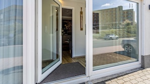 A hotel entrance with a sliding glass door, a welcome sign, and a view of a parking area.