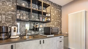A modern kitchen with a chalkboard wall, stainless steel appliances, and a built-in microwave.