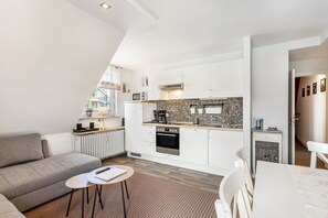 A modern kitchen with white cabinets, a brick backsplash, and a built-in oven.