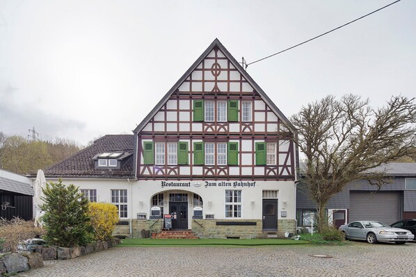 A traditional half-timbered building with a sign reading 'Restaurant Zum alten Bauernhof.'