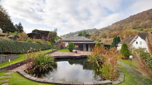 A pond in a garden with a house in the background. - Apartment 'Standfuss' with Private Terrace, Garden, and Wi-Fi (Dausenau)