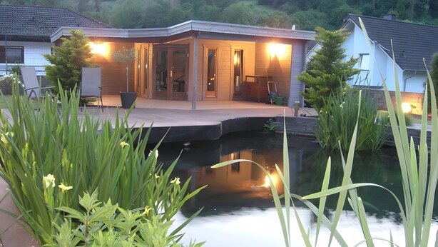 A house with a pond, surrounded by greenery. - Apartment 'Standfuss' with Private Terrace, Garden, and Wi-Fi (Dausenau)