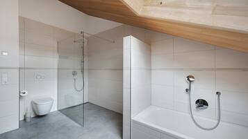 Ein modernes Badezimmer mit Dusche, Toilette und Badewanne.