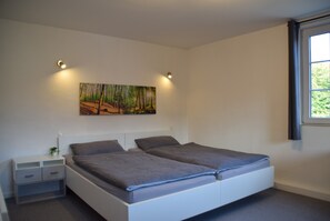 A bedroom with a bed, a nightstand, a painting, and a window. - Apartment with Shared Terrace, Shared Garden and Wi-Fi (Lichtenau)