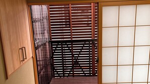 Une pièce de style japonais traditionnel, avec un sol recouvert de tatamis, un paravent coulissant en papier de riz (shoji) et une armoire en bois.