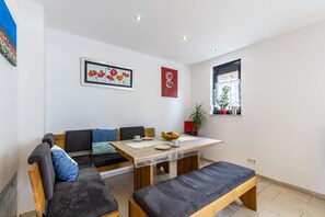 Ein modernes Wohnzimmer mit einer Couch, einem Esstisch und einer Bank.