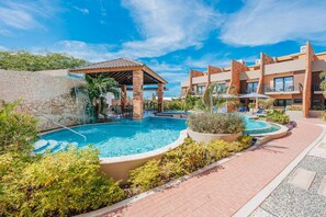 Un complexe hôtelier doté d’une piscine, d’un espace extérieur aménagé et d’une zone couverte.