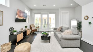 Un salon moderne avec un canapé, une table basse et un téléviseur fixé au mur.