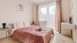 A modern bedroom with a large bed, bedside tables, a desk, and a window with curtains. - Lumina apartments with 2 terrace (Warsaw)