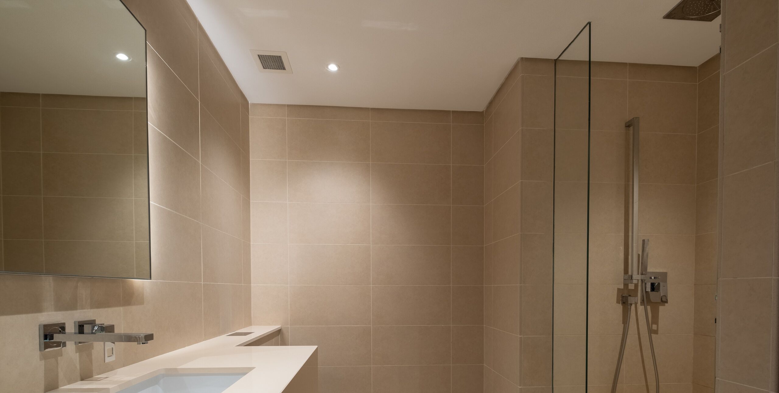 Een moderne badkamer met een grote spiegel, een wastafel en een douchehoek.
