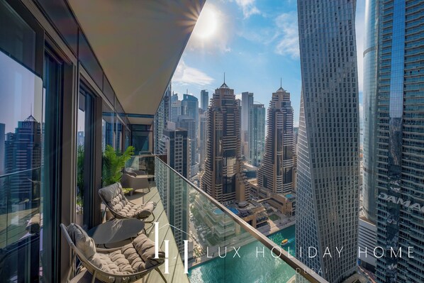 A balcony with a view of Dubai's skyline, including the Burj Khalifa and other high-rise buildings.