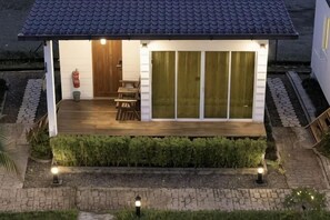 A small house with a wooden deck, a sliding glass door, and a door leading to the interior. - Rich Villa Resort Semporna (Semporna)