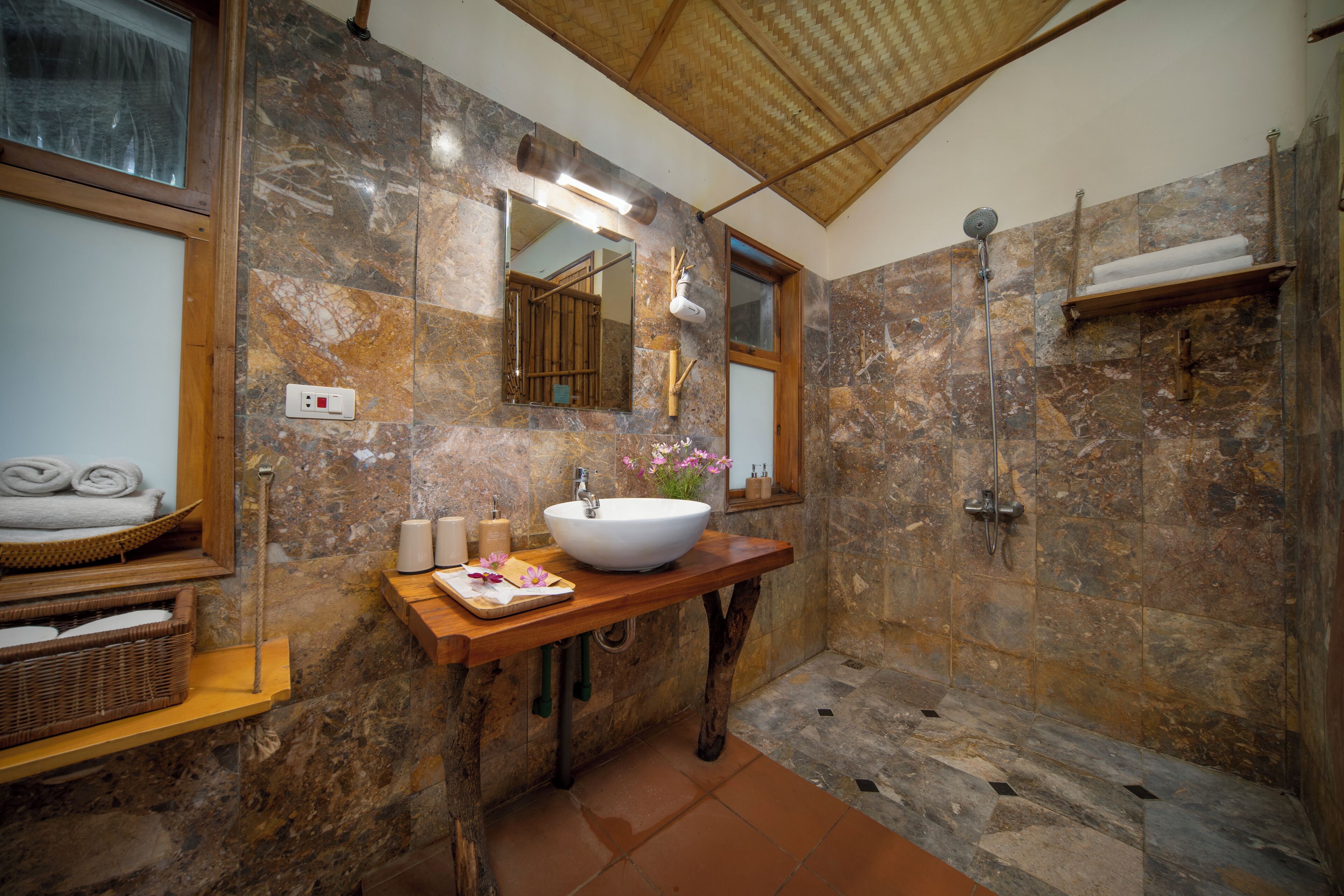 A bathroom with a large sink, mirror, and shower.