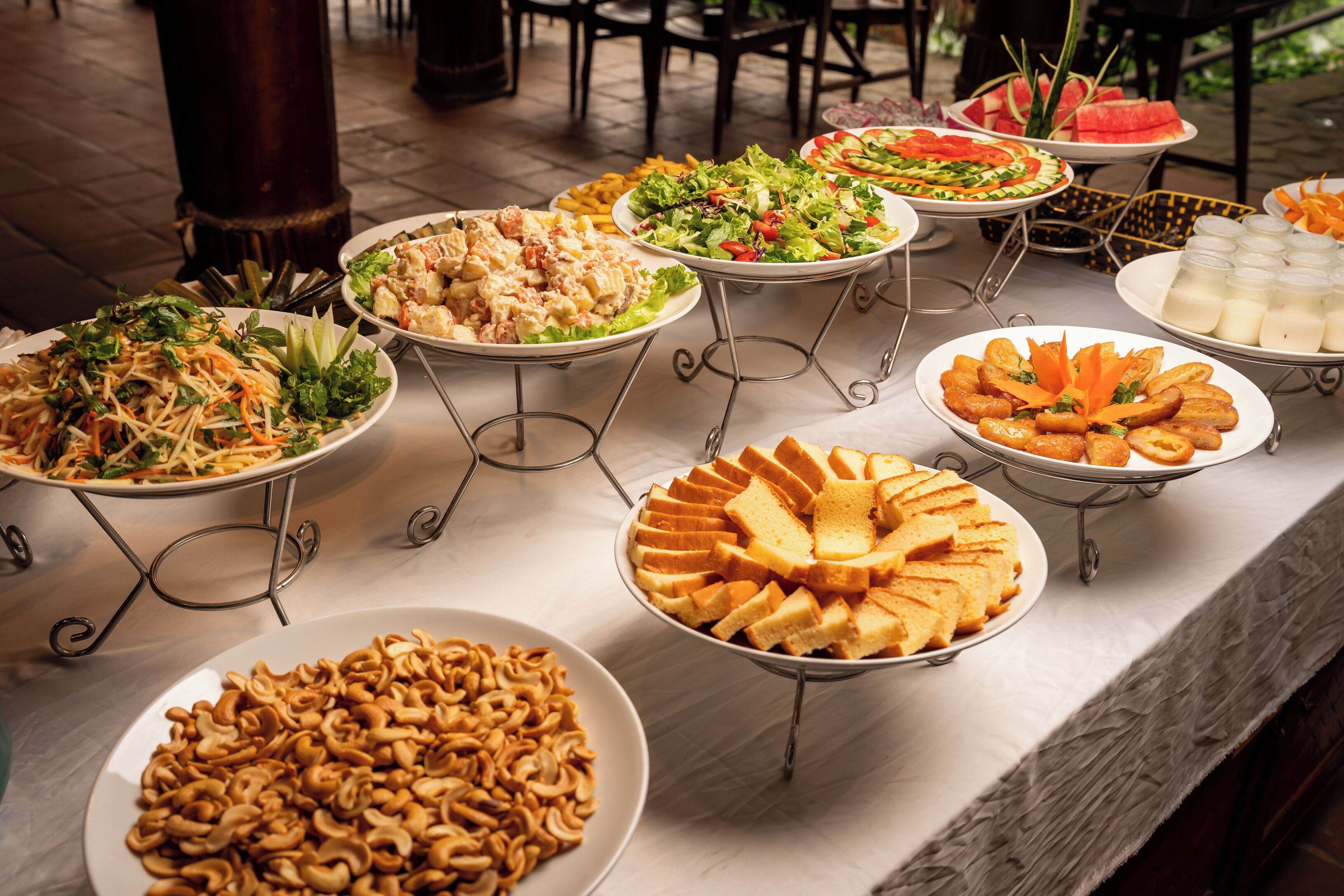 Una mesa de bufé con diversos platos, incluyendo ensaladas, sándwiches y aperitivos.