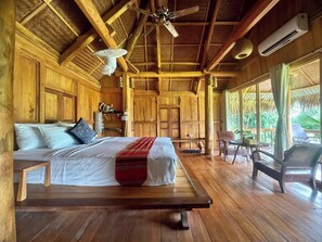 A wooden room with a bed, a ceiling fan, and a window with curtains. - Puluong Retreat (Pu Luong)