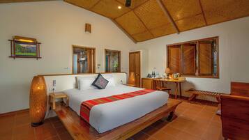 A spacious bedroom with a large bed, wooden furniture, and a ceiling fan.