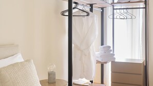 A hotel room with a bed, a bedside table, a wardrobe, and a window with curtains. - The Samirah Luxury Residence C4 (Elliniko - Argiroupoli)