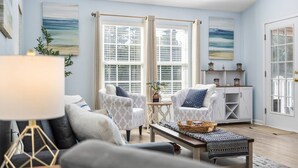 A living room with a sofa, armchairs, a coffee table, and a sideboard.