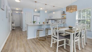 A modern kitchen with white cabinetry, a central island, and pendant lighting.