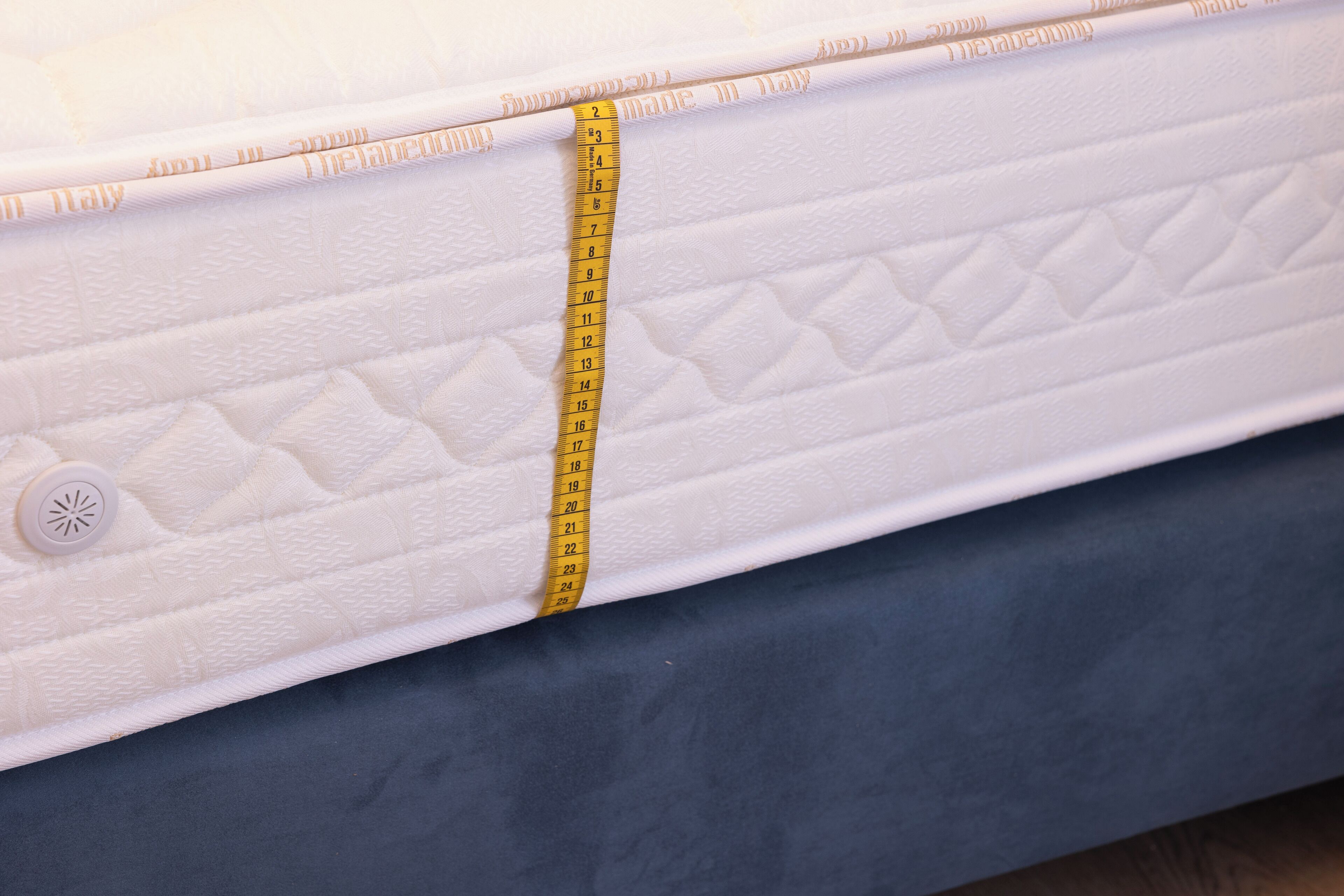 A mattress with a measuring tape, indicating its size.