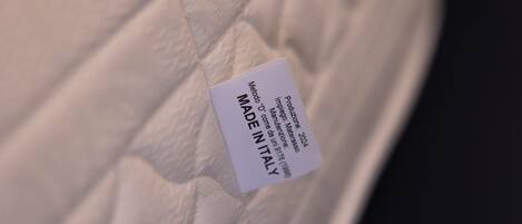 A label on a mattress with text indicating it is made in Italy.
