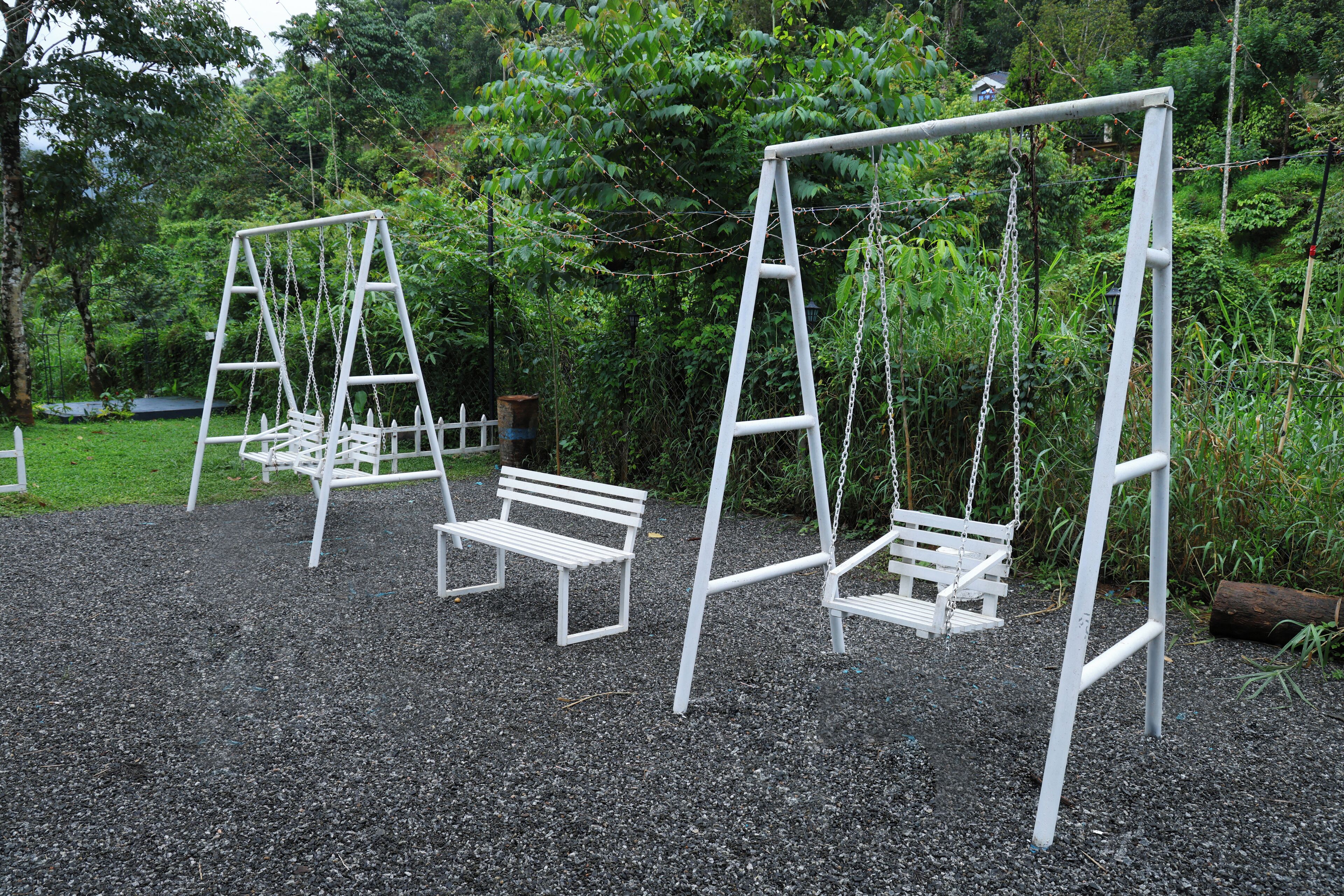 A playground with swings and benches.
